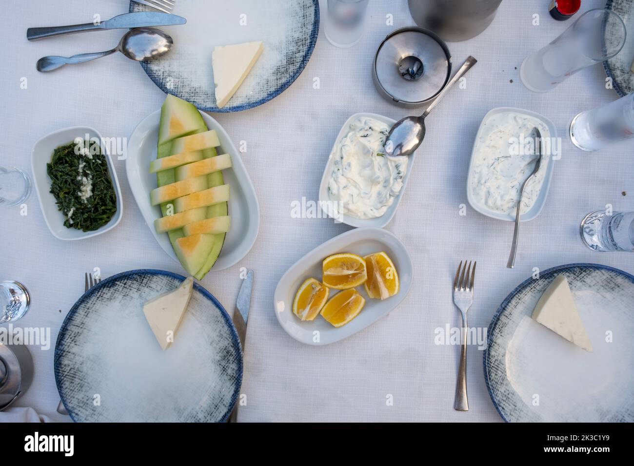 Türkischer Raki-Tisch mit Melone, Zitrone und Vorspeise, traditioneller türkischer Alkohol, bekannt als Rakı, chillen Sie mit Freunden im Restaurant, Essen und Essen Idee Stockfoto