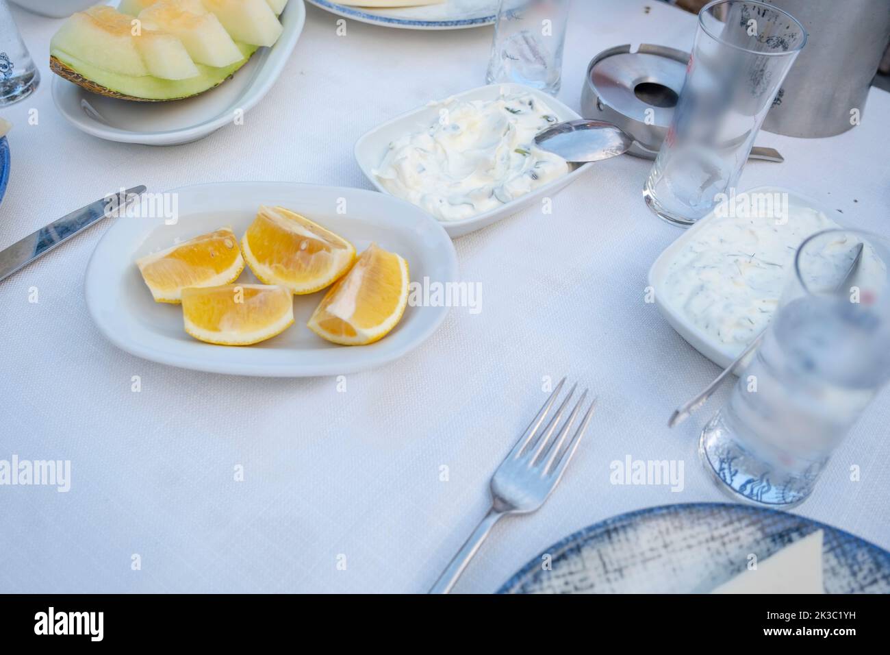Türkischer Raki-Tisch mit Melone, Zitrone und Vorspeise, traditioneller türkischer Alkohol, bekannt als Rakı, chillen Sie mit Freunden im Restaurant, Essen und Essen Idee Stockfoto