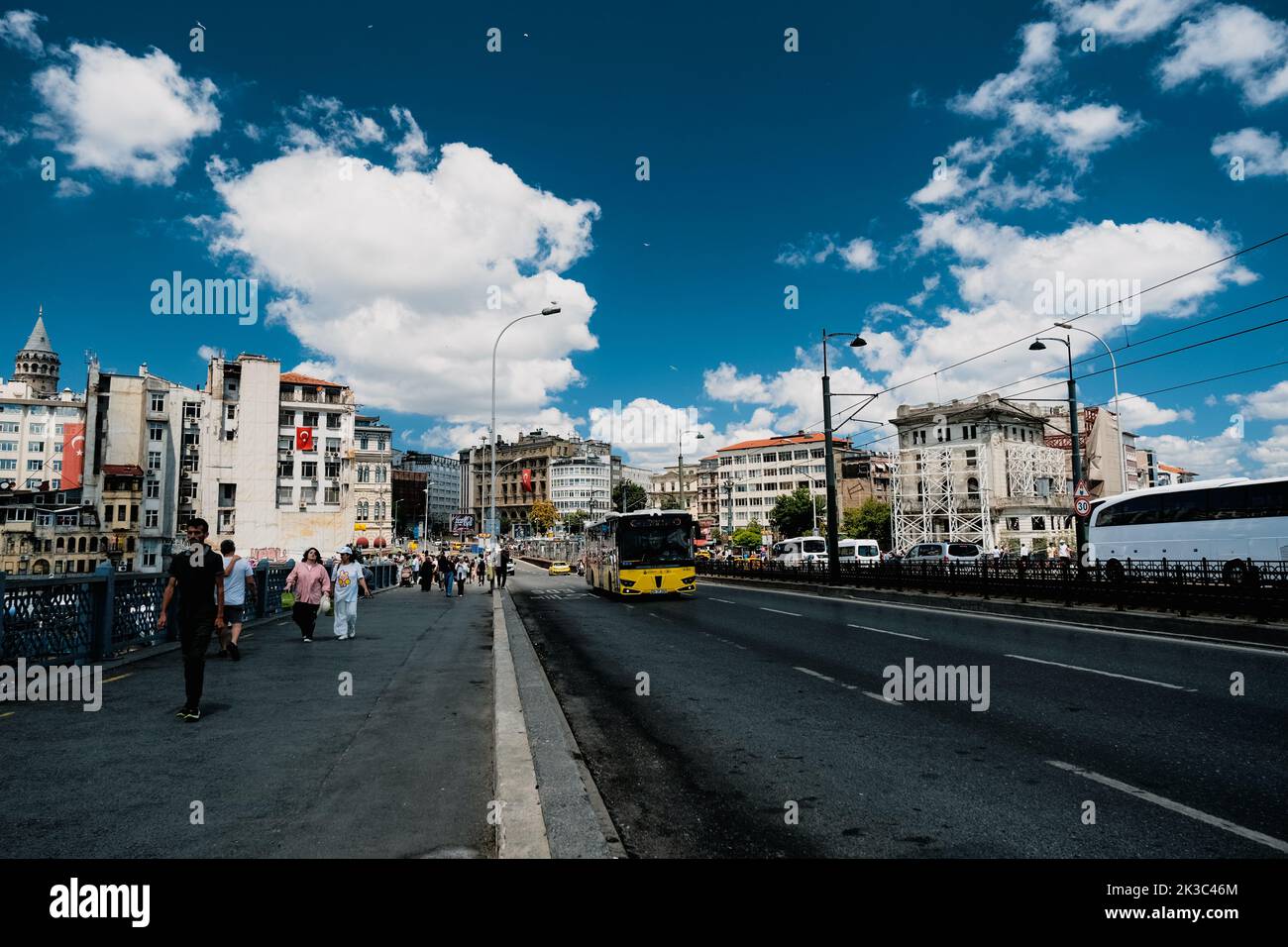Stadtbild von der Galata-Brücke in Istanbul, Menschen, die auf einer Brücke laufen, Autos und Busse im Blick, Reisen und Reisen in Istanbul, blauer bewölktes Himmel im Sommer Stockfoto