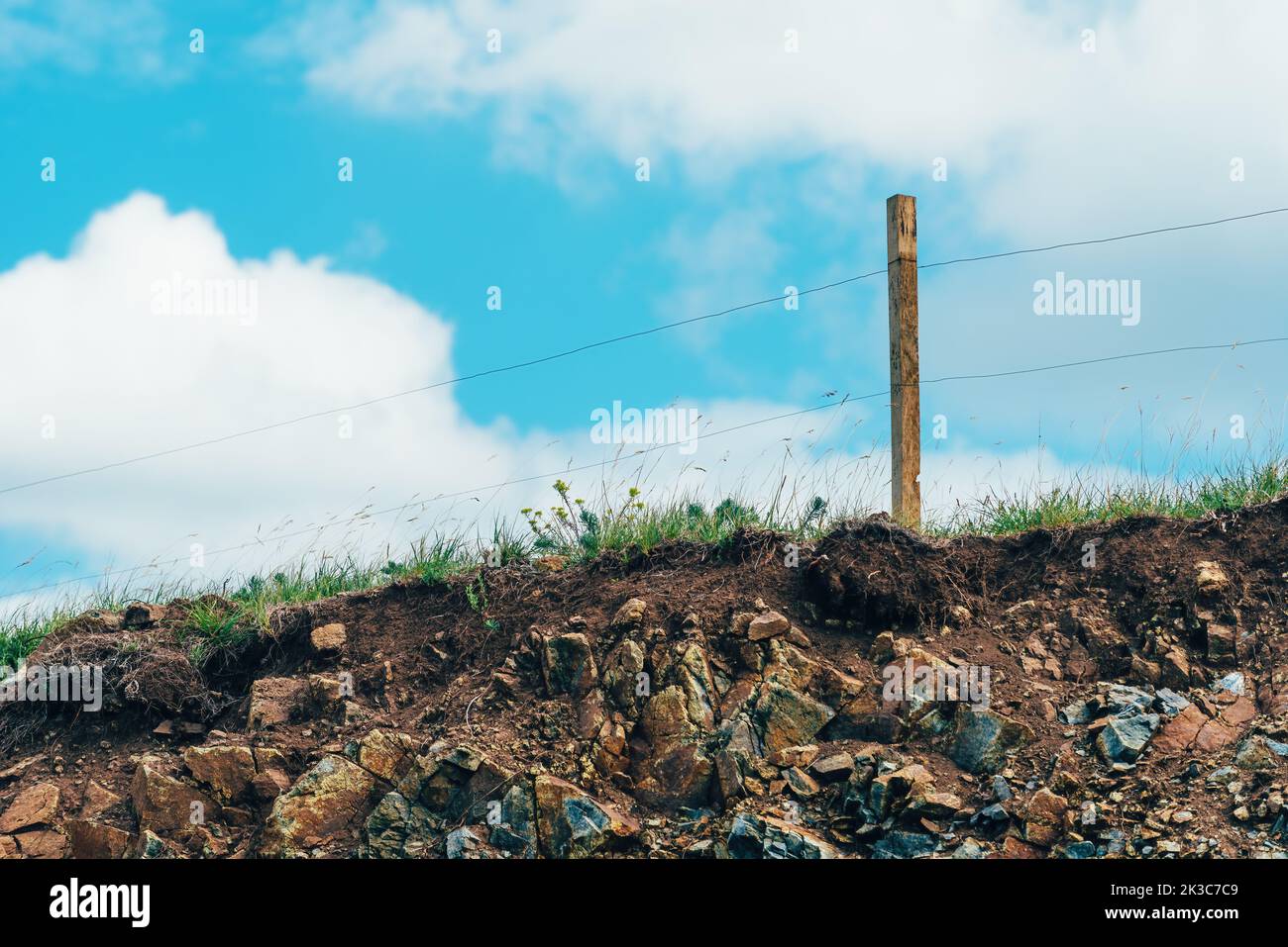 Freilandfarm elektrische Drahtzäune auf Zlatibor Hügeln mit weißen Wolken im Hintergrund, selektiver Fokus Stockfoto