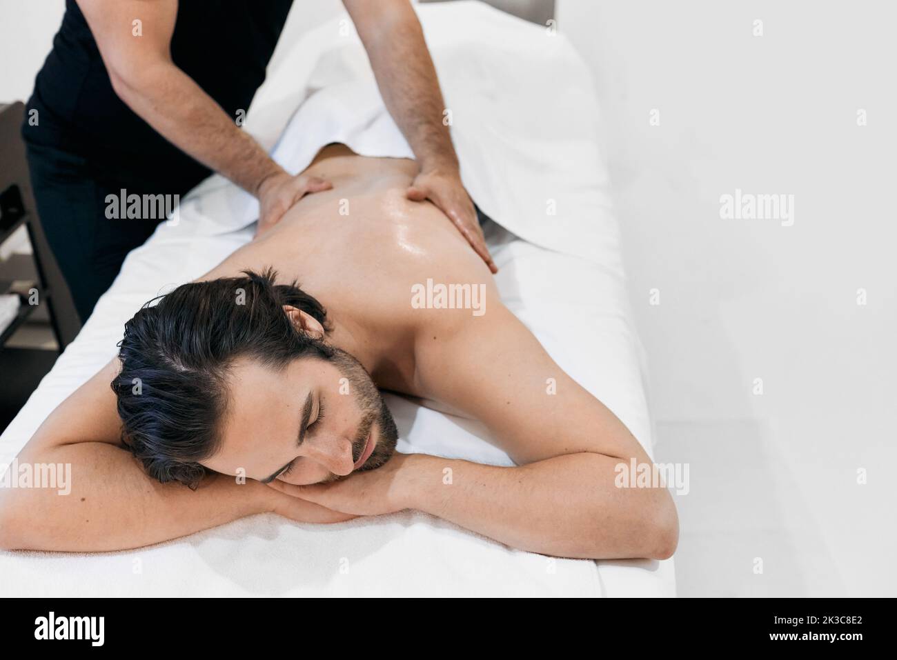 Gutaussehender Mann verbringt Zeit im Spa und bekommt Aromatherapie und Ölmassage. Massage für Männer Stockfoto