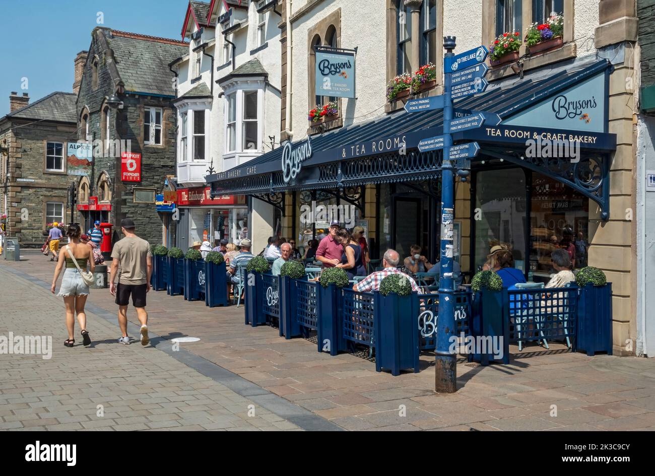 Menschen Touristen Besucher sitzen Abendessen außerhalb Café Restaurant im Stadtzentrum im Sommer Main Street Keswick Cumbria England Großbritannien GB Stockfoto