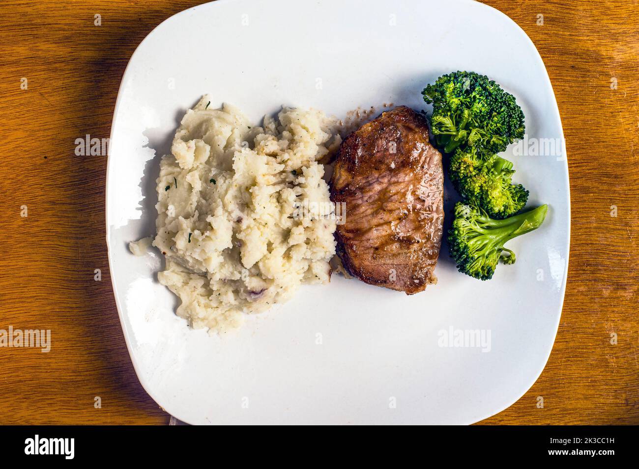 Schweinekotelett ohne Knochen, serviert mit Brokkoli und roten Kartoffelbrei Stockfoto