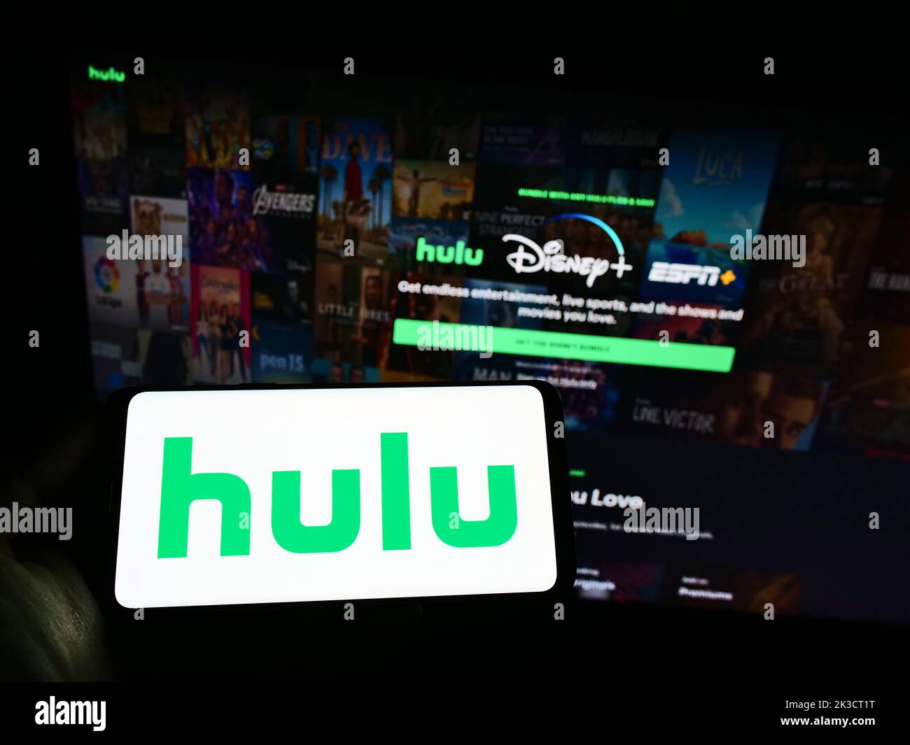Person, die ein Smartphone mit dem Logo des US-amerikanischen Video-Streaming-Service-Unternehmens Hulu LLC auf dem Bildschirm vor der Website hält. Konzentrieren Sie sich auf die Telefonanzeige. Stockfoto