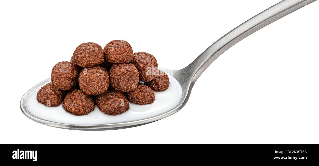 Schokoladen-Maiskugeln mit Milch im Löffel isoliert auf weißem Hintergrund Stockfoto