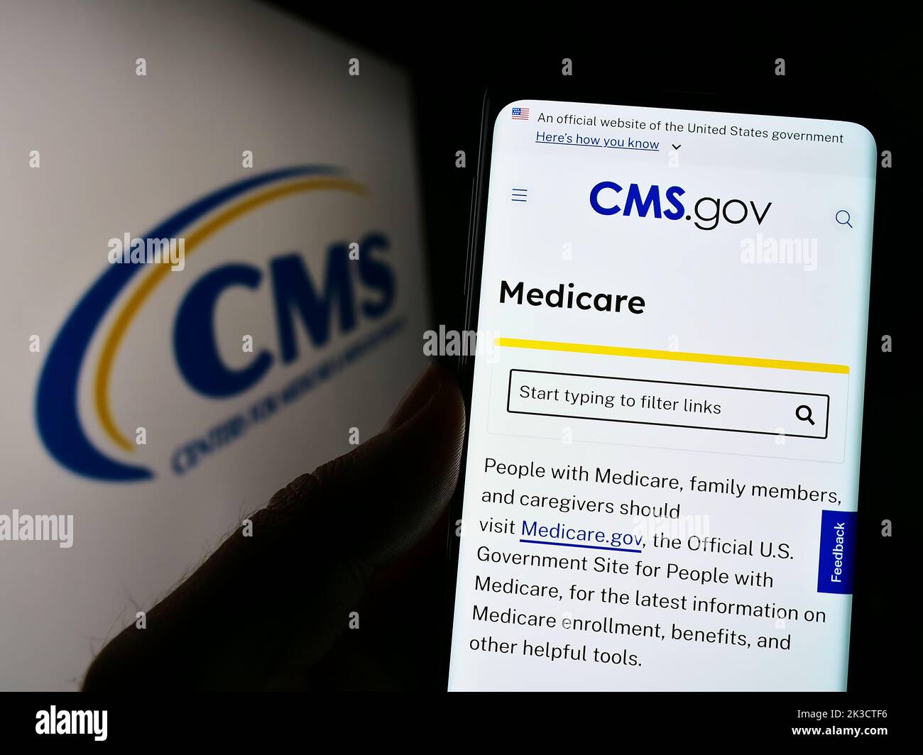 Person, die Mobiltelefon mit der Webseite der Zentren für Medicare und Medicaid-Dienste (CMS) auf dem Bildschirm mit Logo hält. Konzentrieren Sie sich auf die Mitte des Telefondisplays. Stockfoto