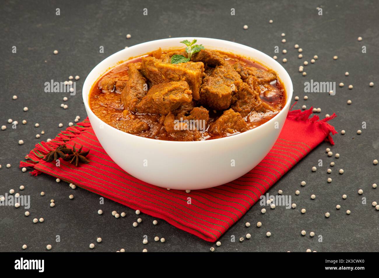 Rind-Masala oder Braten, kerala Stil hausgemachtes Rezept garniert mit Kokosnussstücken und Kerrgeblättern, die in einer weißen Schüssel mit weißem Hintergrund angeordnet ist Stockfoto