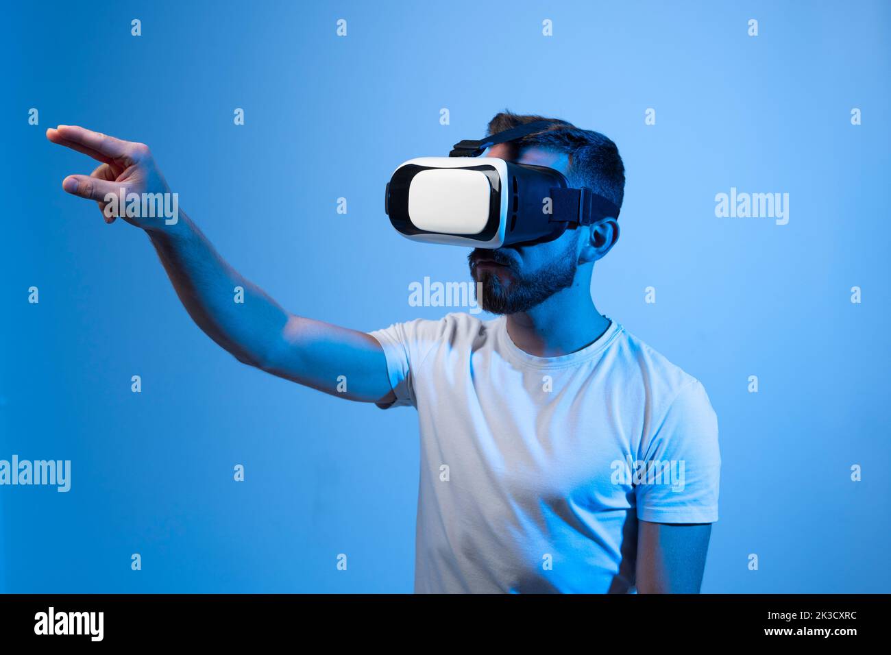 Junger bärtiger Mann, der eine Virtual-Reality-Brille trägt und Videospiele spielt. Stockfoto
