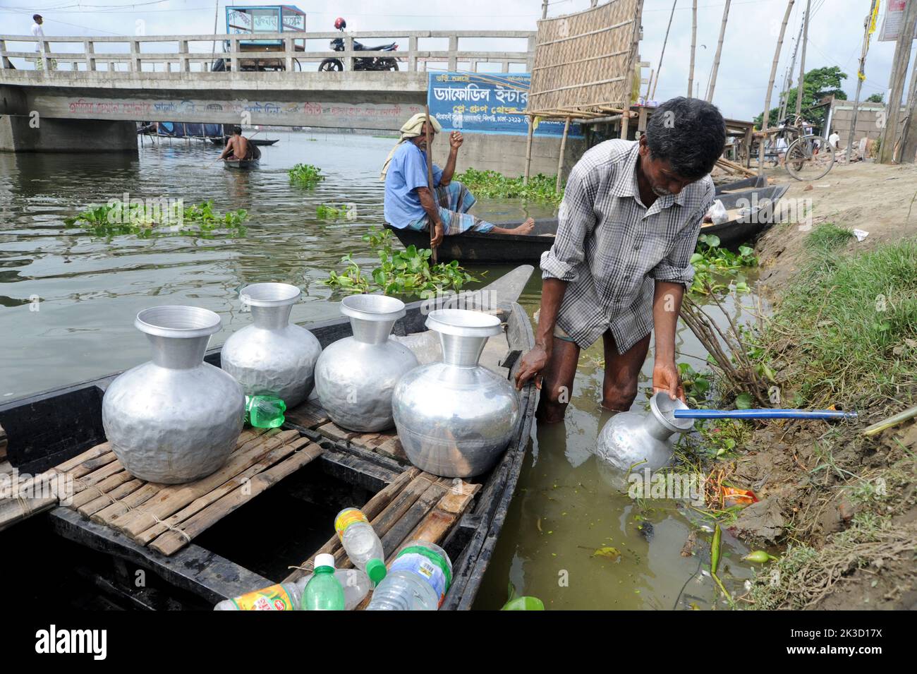 Dhaka, Bangladesch - 16. Juli 2010: Die Bewohner von Dhakas Nandipara sammeln mit dem Boot frisches Wasser von der Wasa-Rohrleitung, weil Wasser herumkommt Stockfoto