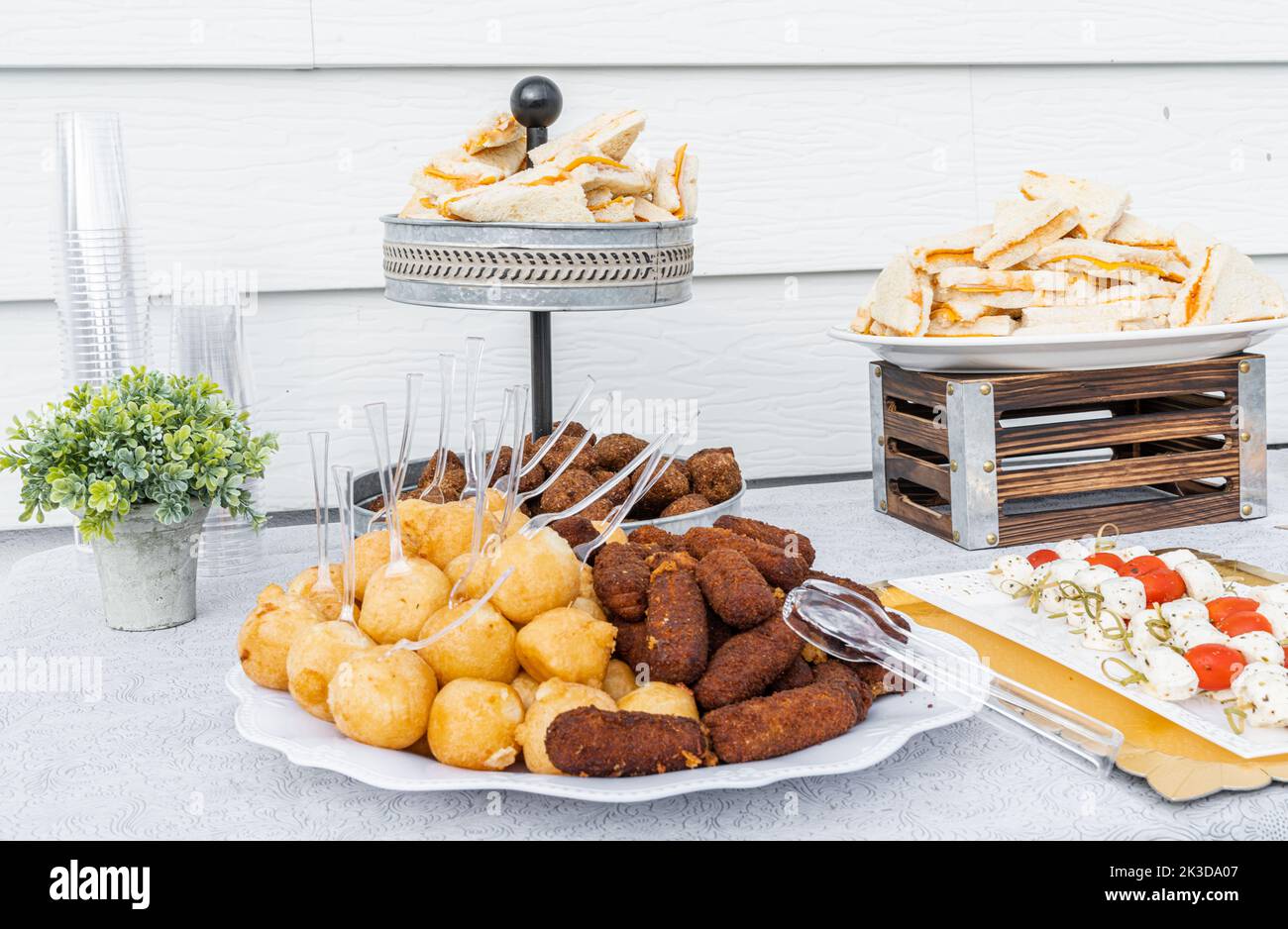 Tisch serviert mit Käsesandwiches, gefüllten Kartoffeln, Schweinskroketten und Dominikanerkipes. Stockfoto