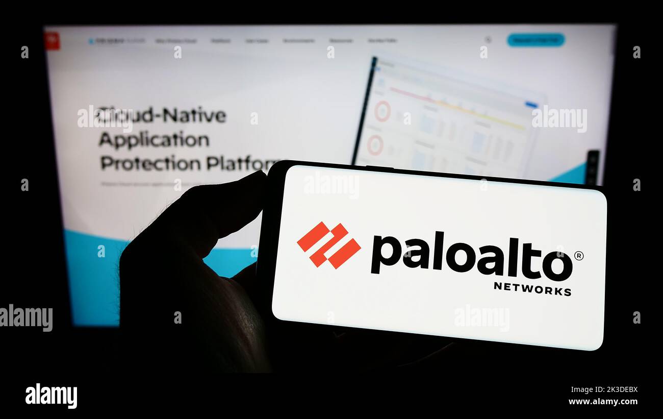 Person, die Mobiltelefon mit dem Logo des amerikanischen Cybersicherheitsunternehmens Palo Alto Networks Inc. Auf dem Bildschirm vor der Webseite hält. Konzentrieren Sie sich auf die Telefonanzeige. Stockfoto