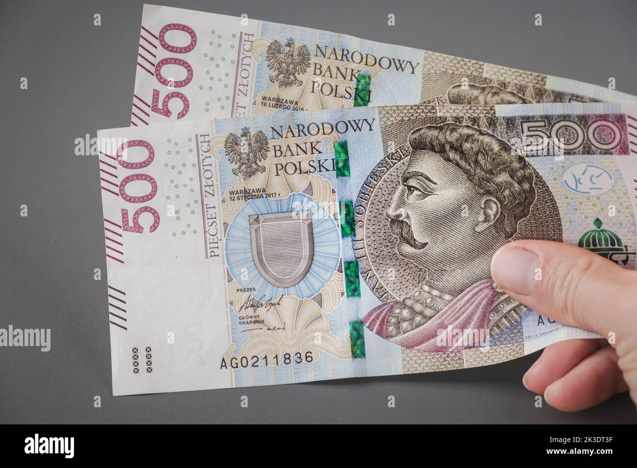 Bezahlen, geben, polnisches Geld empfangen. Hand mit 500 Zloty Banknote. Gehalt Polen. Stockfoto