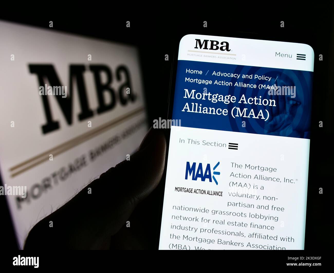 Person hält Handy mit Webseite der Organisation Mortgage Bankers Association (MBA) auf dem Bildschirm mit Logo. Konzentrieren Sie sich auf die Mitte des Telefondisplays. Stockfoto