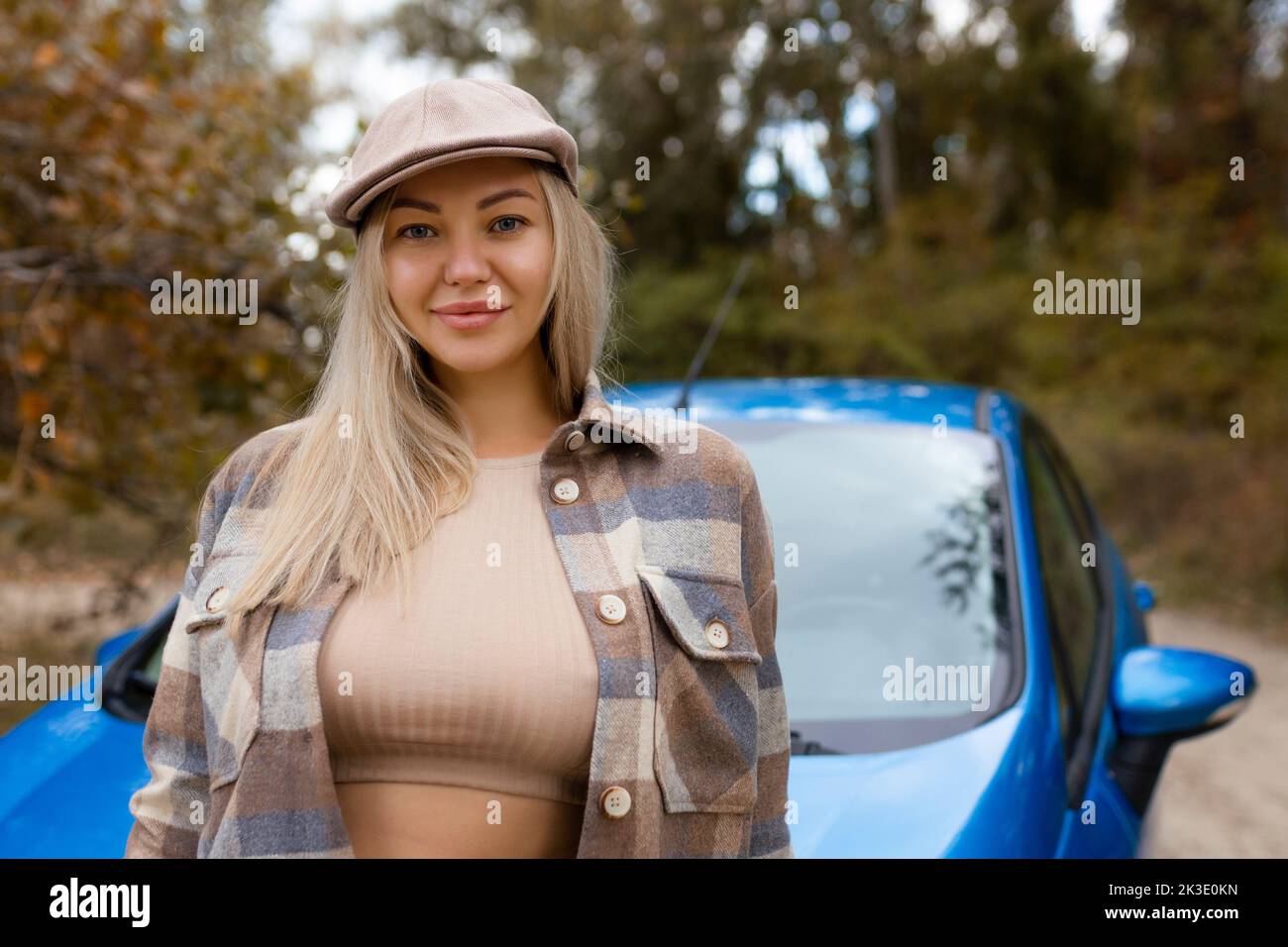 Sexy Mädchen posiert außerhalb des Autos im Herbst in modischer Kleidung Stockfoto