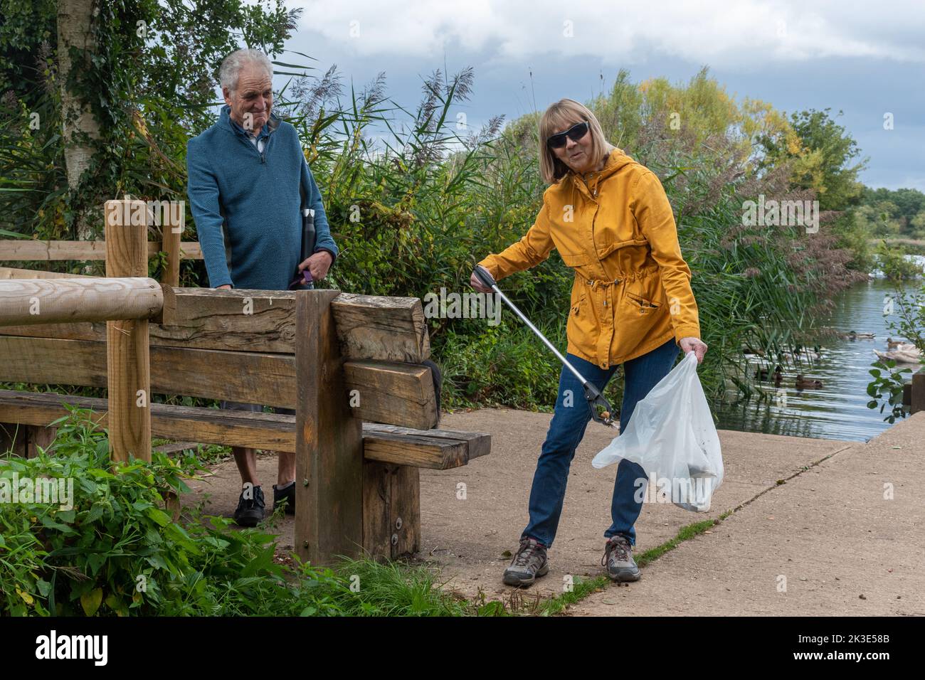 Ältere Paares sammeln Müll, Müllsammler aufräumen Landwege rund um Fleet Pond lokales Naturschutzgebiet, Hampshire, England, Großbritannien Stockfoto