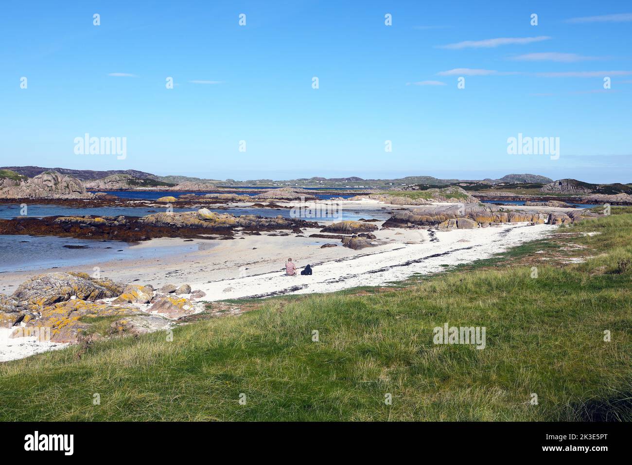 Die weißen Sandstrände von Fidden Beach und rosafarbene Granitaufschlüsse auf der Isle of Mull mit Blick auf die Isle of Iona Stockfoto