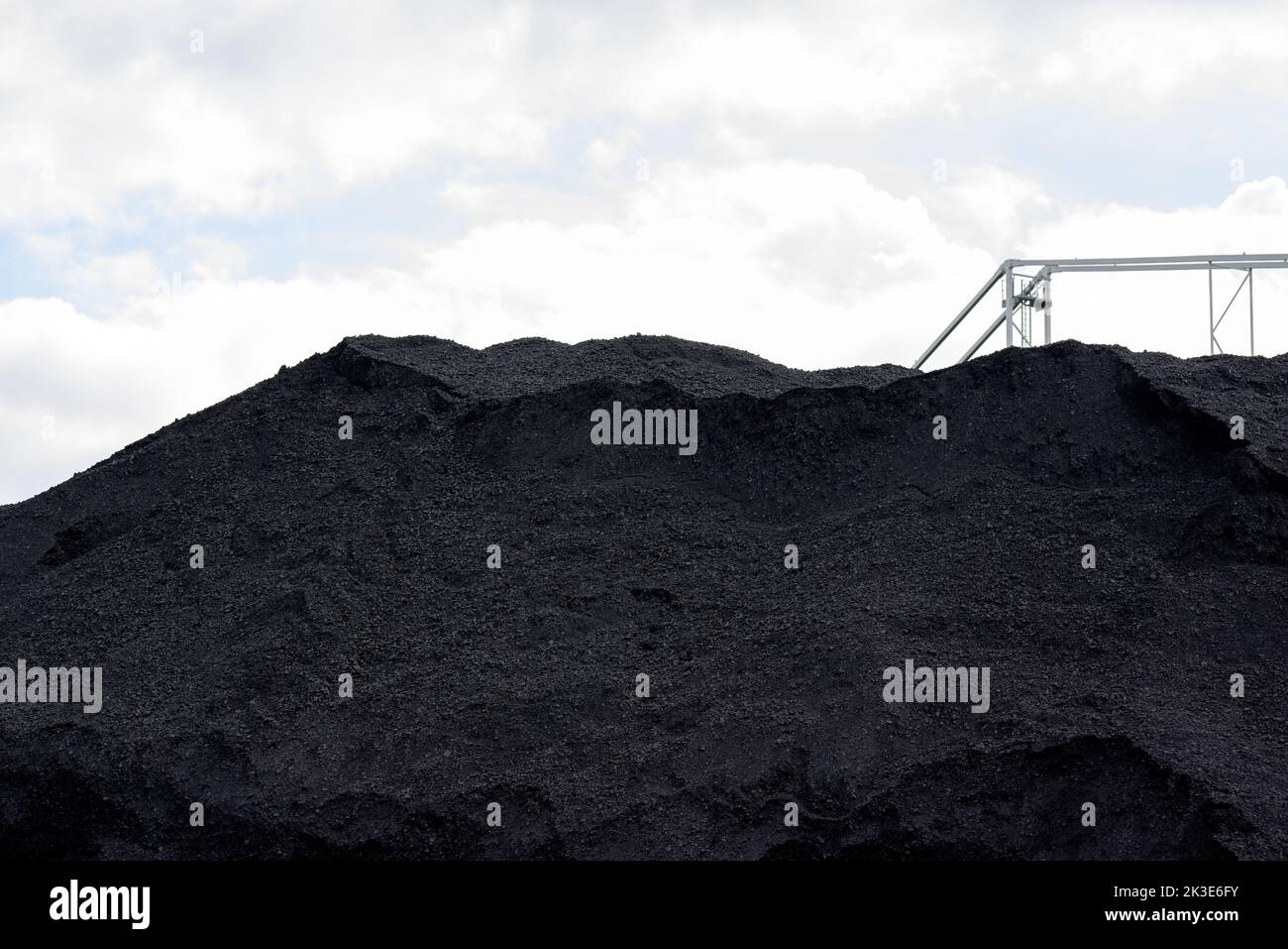 Riesiger Berg aus Steinkohle und einer Stahlkonstruktion für den Transport von Kohle in einem Konzept der Energiekrise und Energieknappheit Stockfoto
