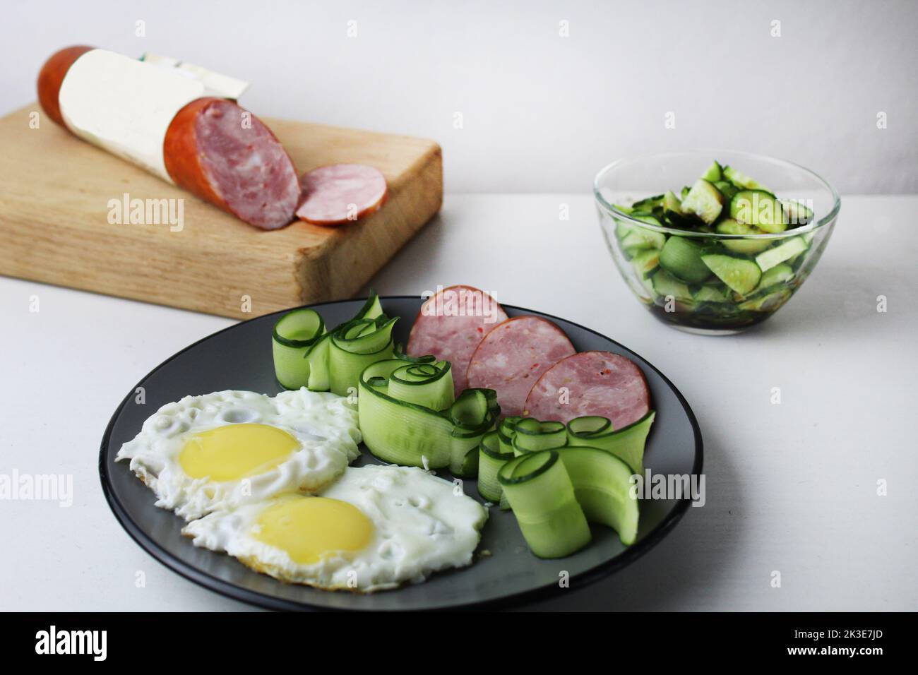 Zastrak-Eier Rühreier Wurst Salat Gurken auf der Trael Blick von der Seite oben. Traditionelles englisches amerikanisches Frühstück. Erste Mahlzeit. Das Benef Stockfoto