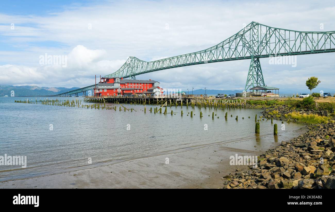 Astoria, OR, USA - 14. September 2022; Astoria Megler Bridge über den Columbia River zwischen Oregon und Washington und über der roten Boutique Cannery Stockfoto