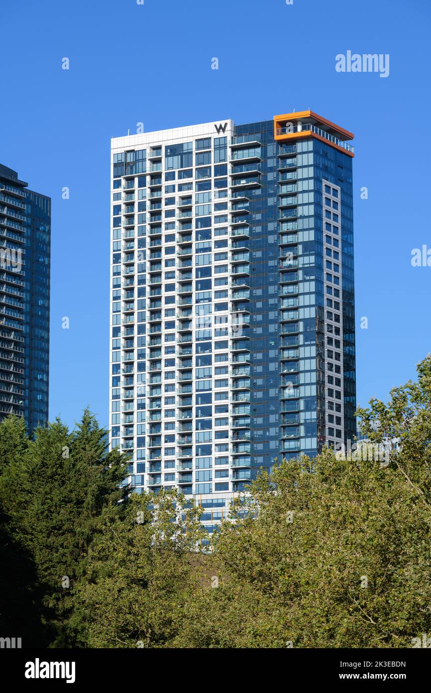 Bellevue, WA, USA - 07. September 2022; W Hotel Wolkenkratzer mit Apartments in Bellevue vor blauem Himmel und Baum im Vordergrund Stockfoto