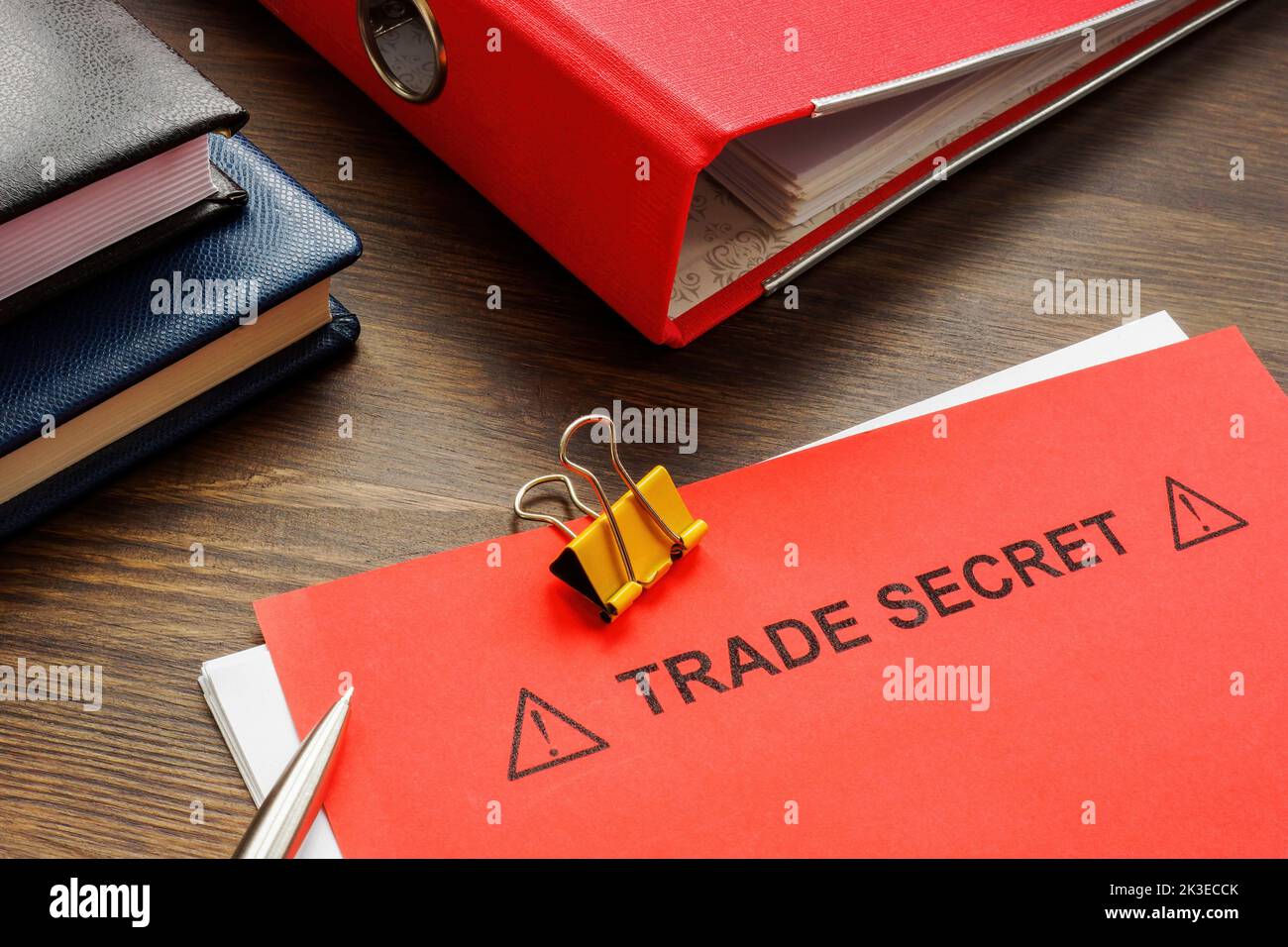 Papiere mit Handelsgeheimnis und einem roten Ordner. Stockfoto