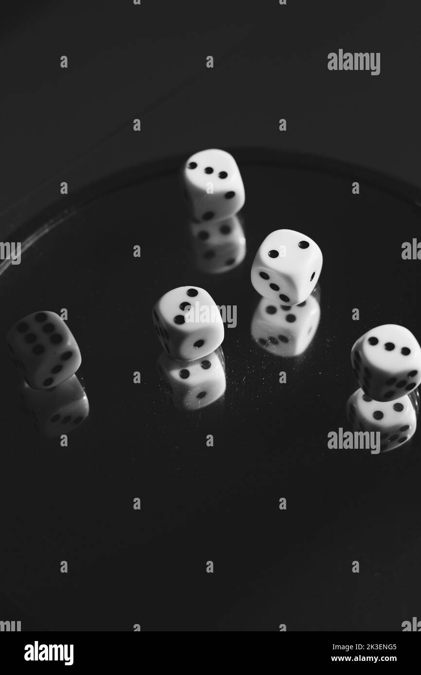 Würfelspiel auf Glas mit Reflexionen darin. Schwarzweiß-Foto Stockfoto