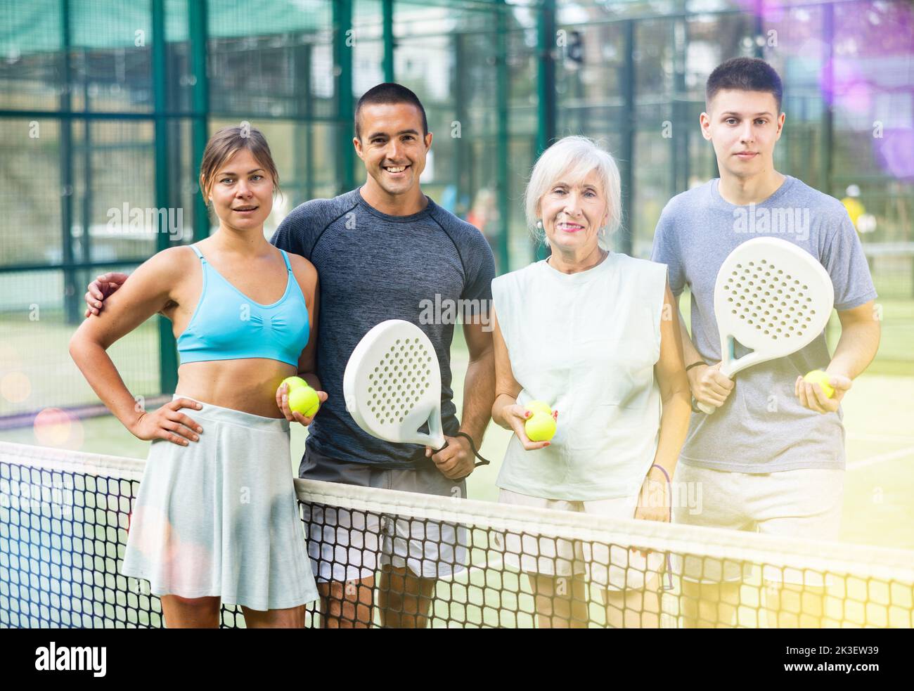 Porträt von vier glücklichen Padel-Spielern auf dem Tennisplatz im Freien Stockfoto