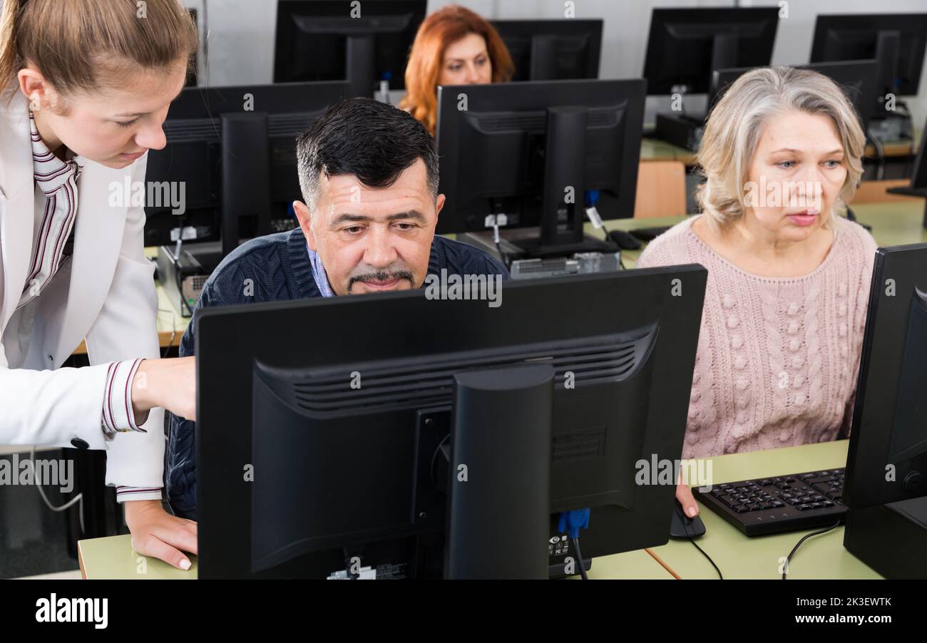Lehrerin erklärt dem reifen Mann Stockfoto