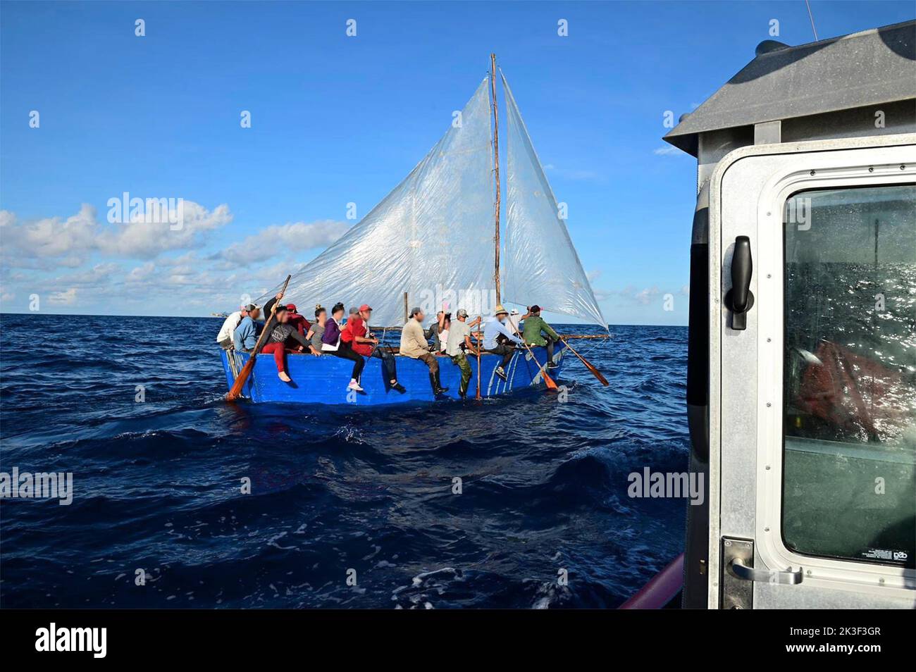 Karibisches Meer, Cayman-Inseln. 25. September 2022. Ein Polizeipersonal der Küstenwache stoppt ein selbstgebackenes Segelboot, das kubanische Migranten trägt und versucht, vor dem 25. September 2022 in der Nähe der Cayman-Inseln vor der anhaltenden politischen Instabilität zu fliehen. Quelle: Coast Guard Handout/USCG/Alamy Live News Stockfoto