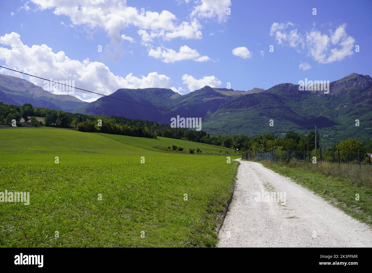 Straße mit Sibillini Bergen im Hintergrund. Stockfoto