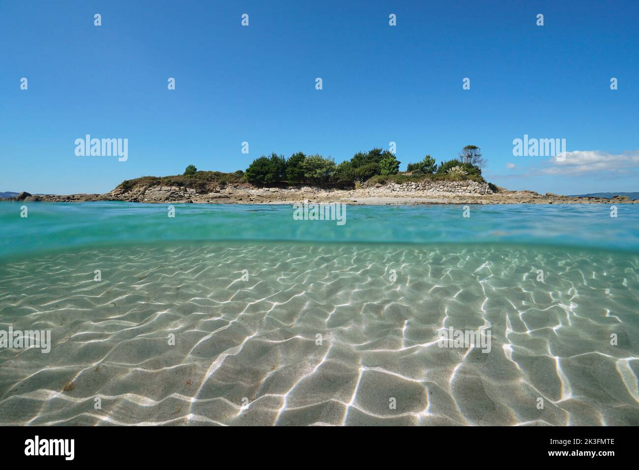 Kleine Insel von der Meeresoberfläche aus gesehen mit Sand unter Wasser, Spanien, Galizien, Rias Baixas, Illa do Santo do Mar, Atlantik, Split Level View Stockfoto