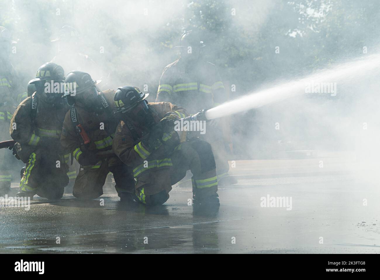 Feuerwehrleute mit den 914. Fire Emergency Services arbeiten zusammen, um einen Wasserschlauch zu kontrollieren, während sie einen Flugzeugstrukturbrand in einer Trainingseinrichtung in Rochester, New York, 24. August 2022, auslösten. Die Schulung für einen Flugzeugbrand verbessert die Einsatzbereitschaft unserer Feuerwehrleute, indem sie ihnen praktische Erfahrung gibt, wie sie die Flammen so schnell wie möglich unterdrücken und schließlich löschen können, um weitere Schäden oder Verletzungen zu vermeiden. (USA Luftwaffe Foto von Airman Kylar Vermeulen) Stockfoto