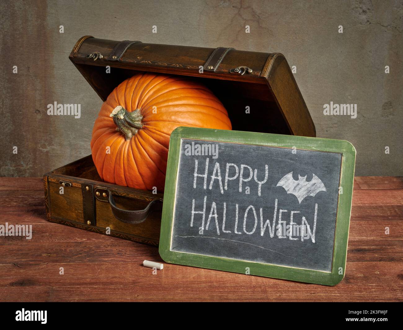 Happy Halloween Tafel Schild mit einem großen Kürbis in einem kleinen Retro Koffer, Grußkarte Stockfoto