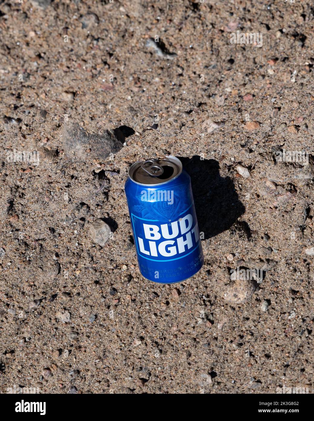 Abfall - eine leere Bud Leichtes Bier kann im Sand und Kies am Straßenrand in den Adirondack Mountains, NY, zurückgelassen werden Stockfoto