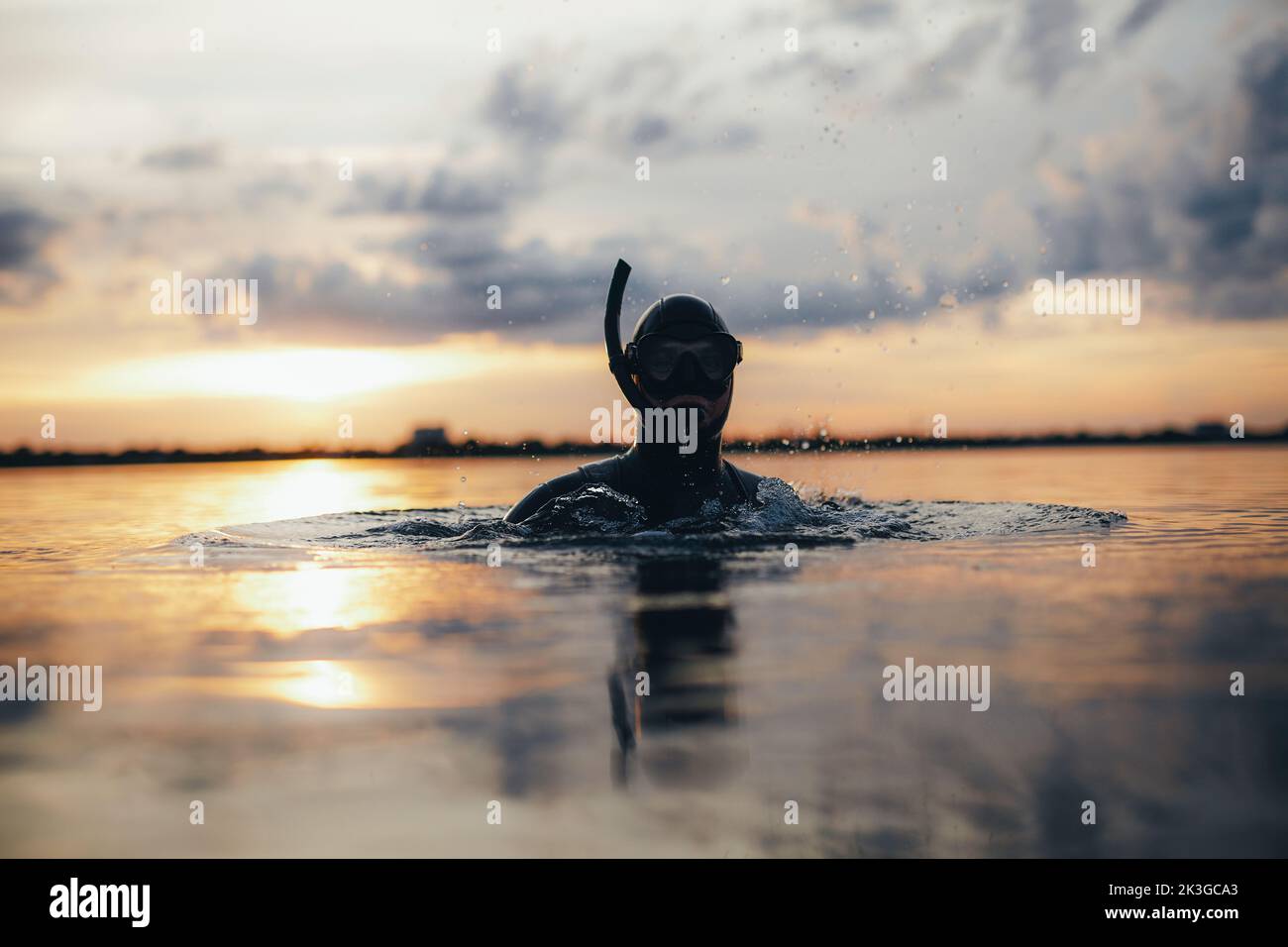 Aufnahme eines männlichen Tauchers mit Schnorchelausrüstung, die in Meerwasser getaucht ist. Abenteuerlicher junger Mann, der mitten im Meer schnorchelt. Stockfoto