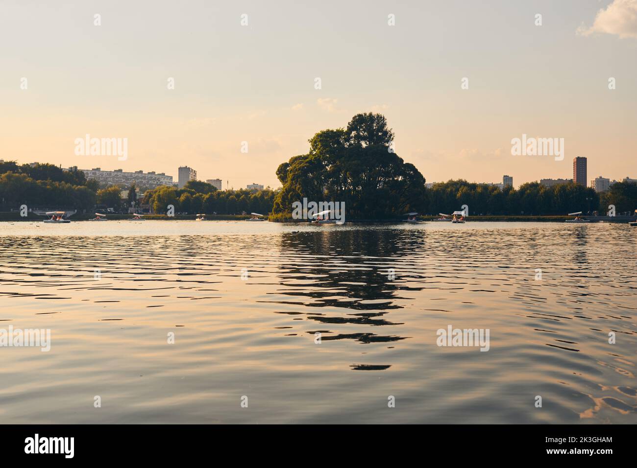 Die Menschen entspannen sich im Sommer im Park am Teich, Bootstouren und Katamarane. Vorderansicht. Stockfoto