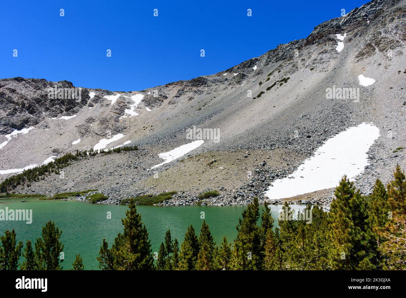 Malerischer Barney Lake, umgeben von einem steilen Bergrücken mit kleinen Schneeflecken in der Nähe von Mammoth Lakes, Kalifornien Stockfoto