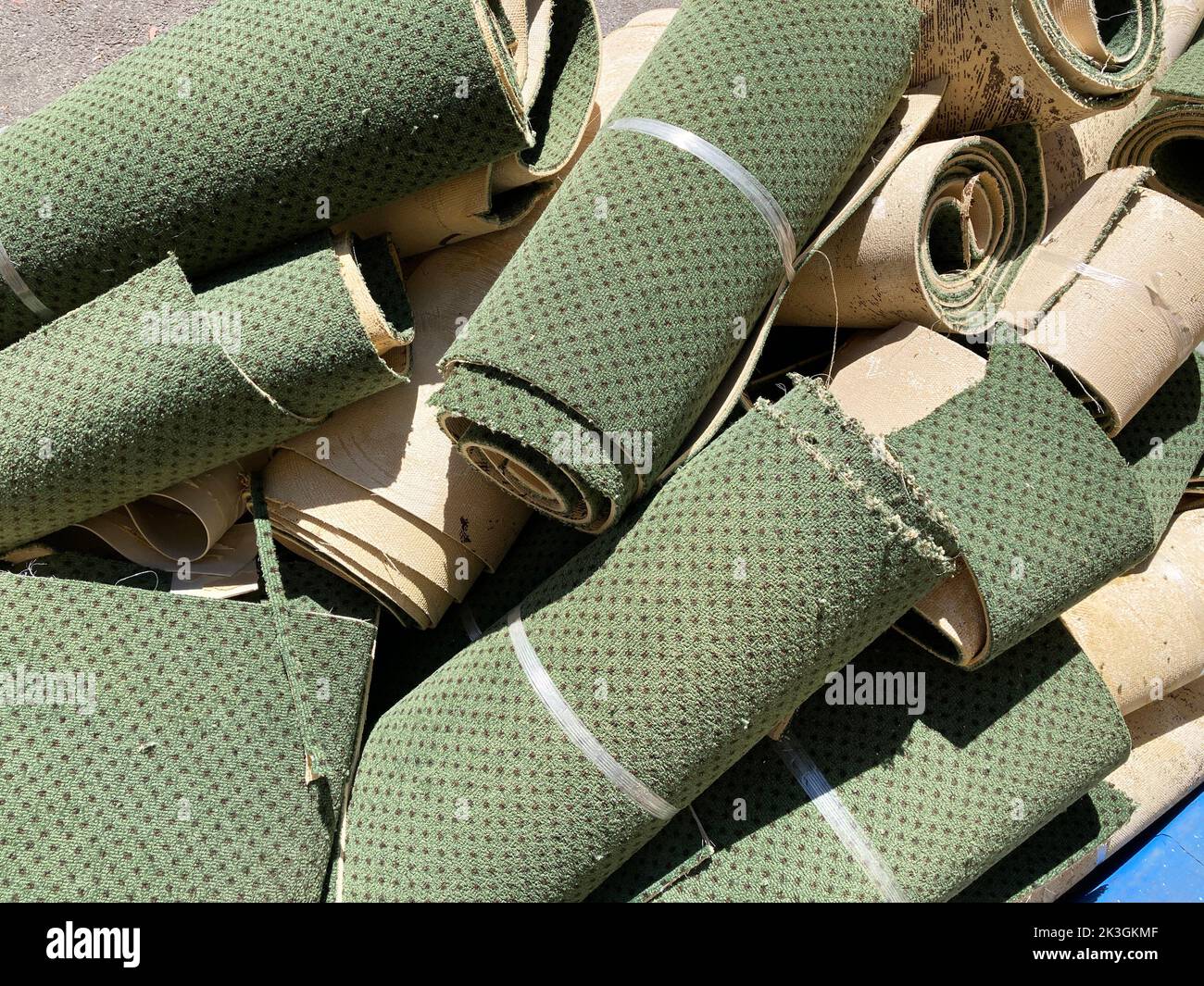 Zerschnittener und gewalzter alter Teppich ist bereit für den Transport. Stockfoto