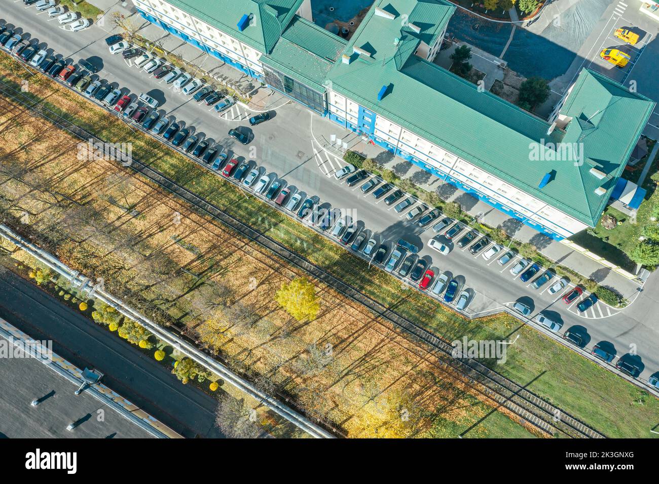 Bürogebäude und Parkplätze mit geparkten Autos. Stadtbild an sonnigen Tagen. Stockfoto