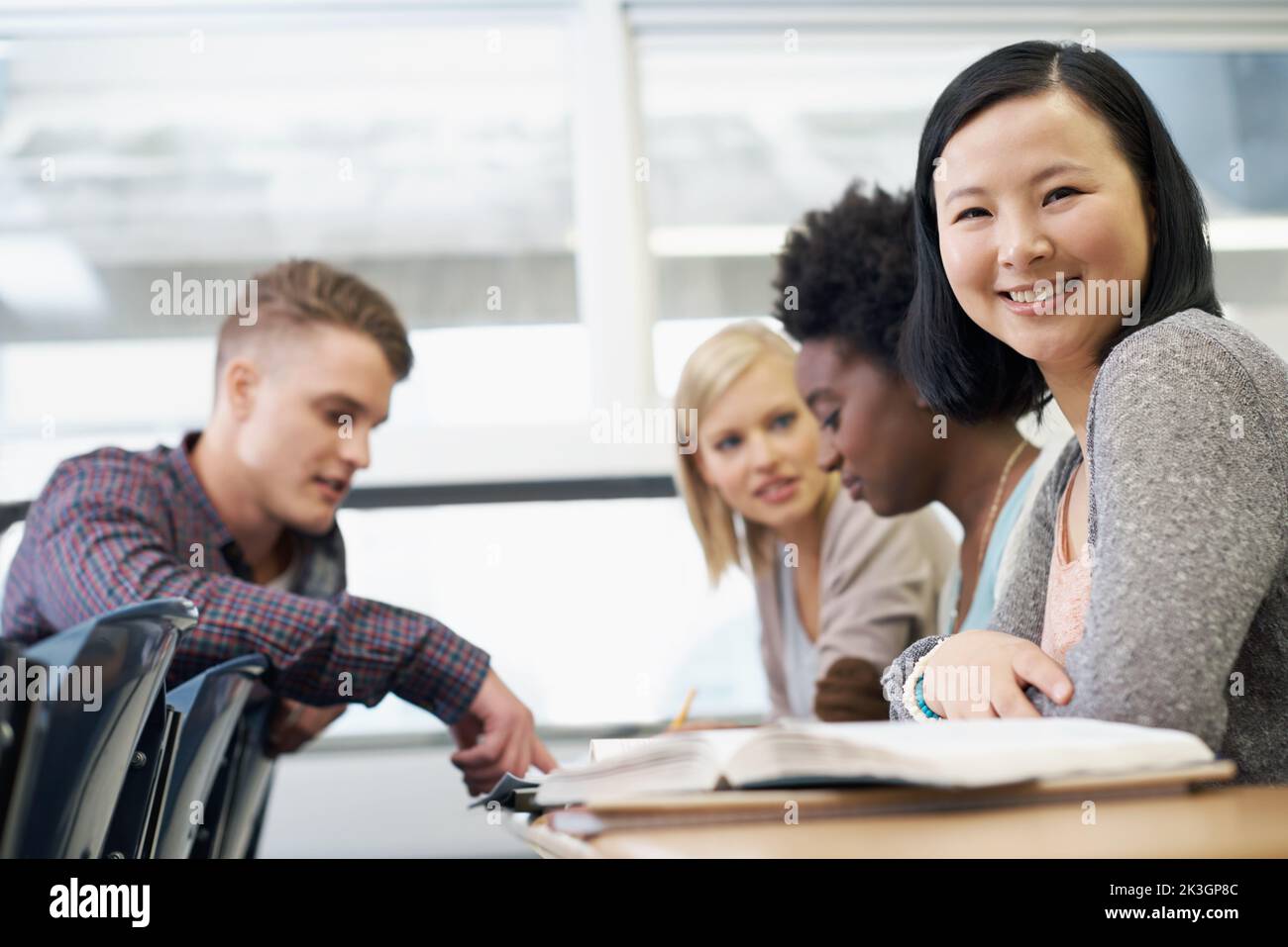 Gemeinsam über die Lernnotizen gehen. Eine Gruppe von Studenten, die in der Klasse sitzen und ihre Hausaufgaben überarbeiten. Stockfoto