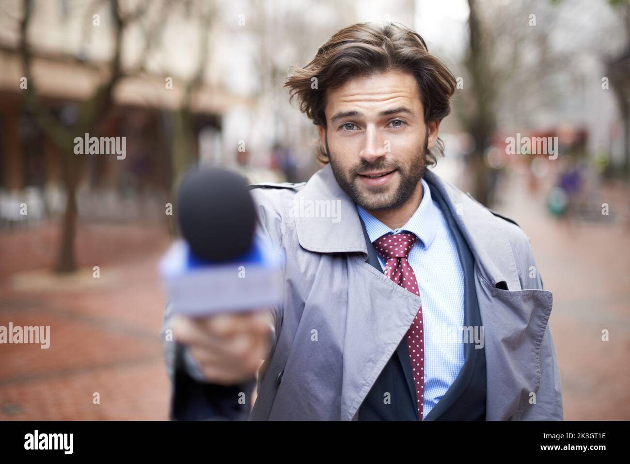 Achten Sie auf Kommentare. Beschnittenes Porträt eines gutaussehenden Nachrichtenreporters, der ein Interview führt. Stockfoto