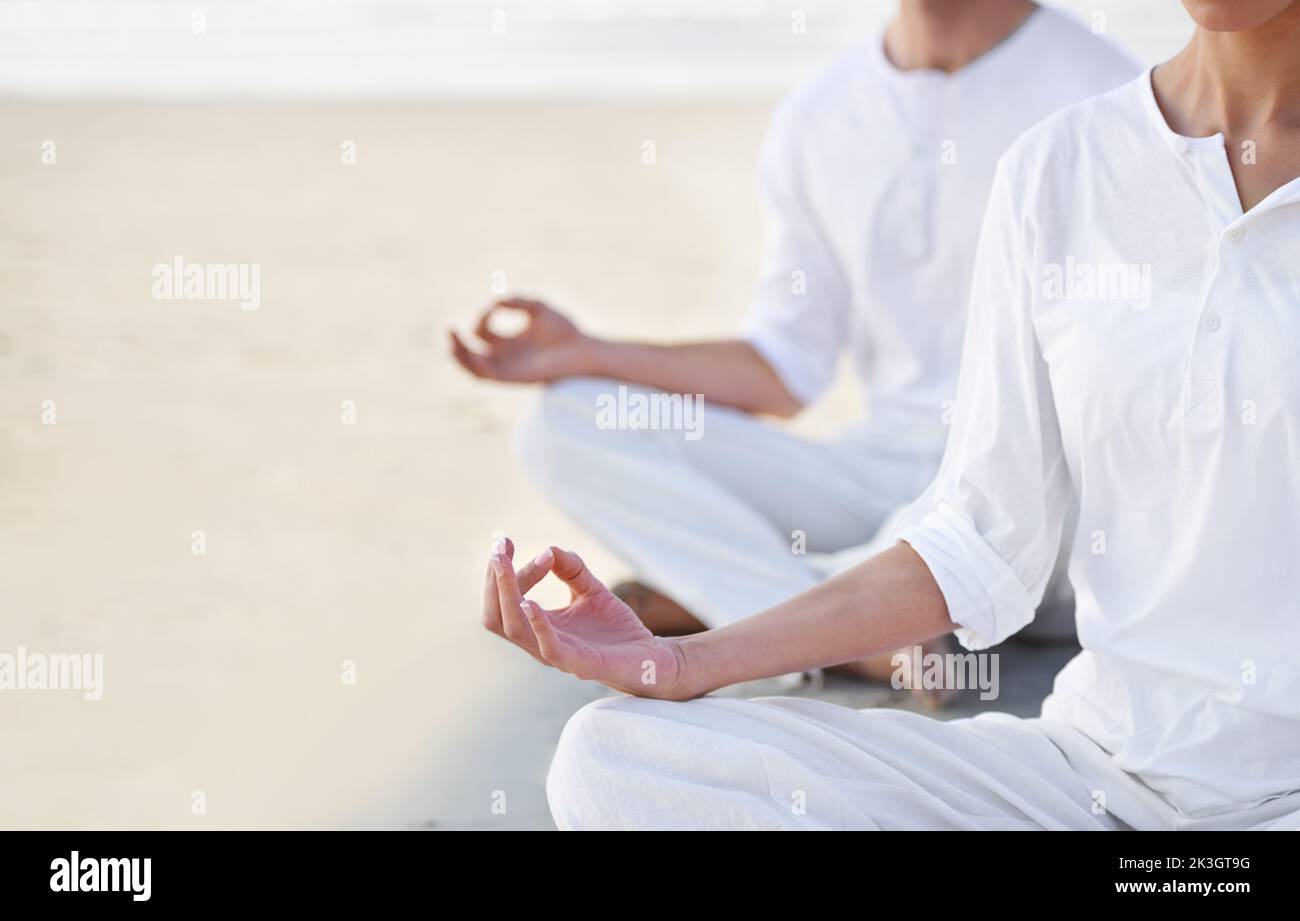 Zwei Menschen in der Lotusposition auf dem Beacj. Stockfoto