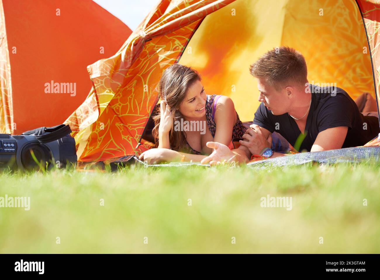 Sie teilen die Liebe zum Campen. Ein glückliches junges Paar liegt in einem Zelt. Stockfoto