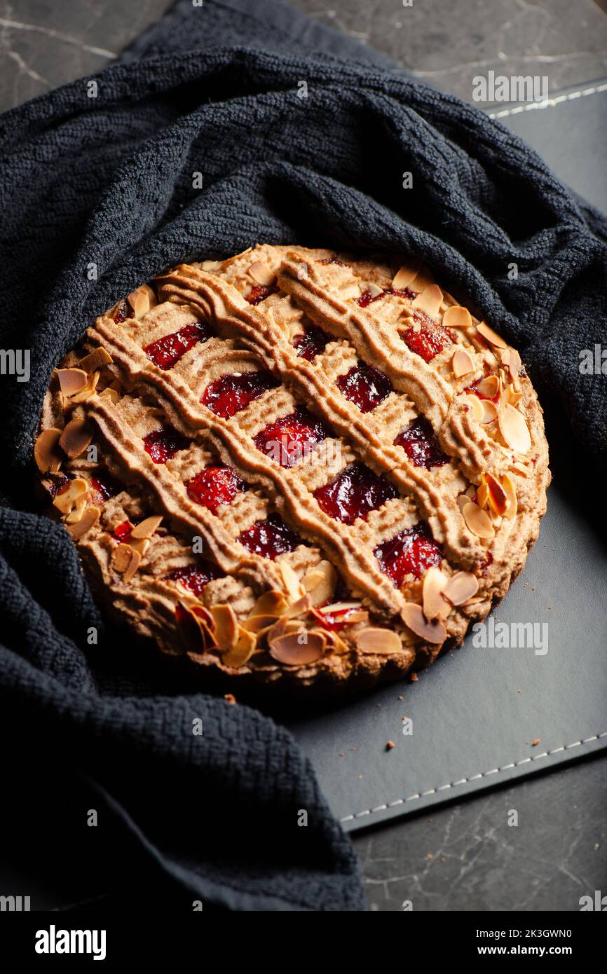 Die Linzer Torte ist ein traditionelles österreichisches Gebäck, eine Form von Shortbread, gekrönt mit Fruchtkonserven und geschnittenen Nüssen mit einem Gitterdesign auf der Oberseite. Stockfoto