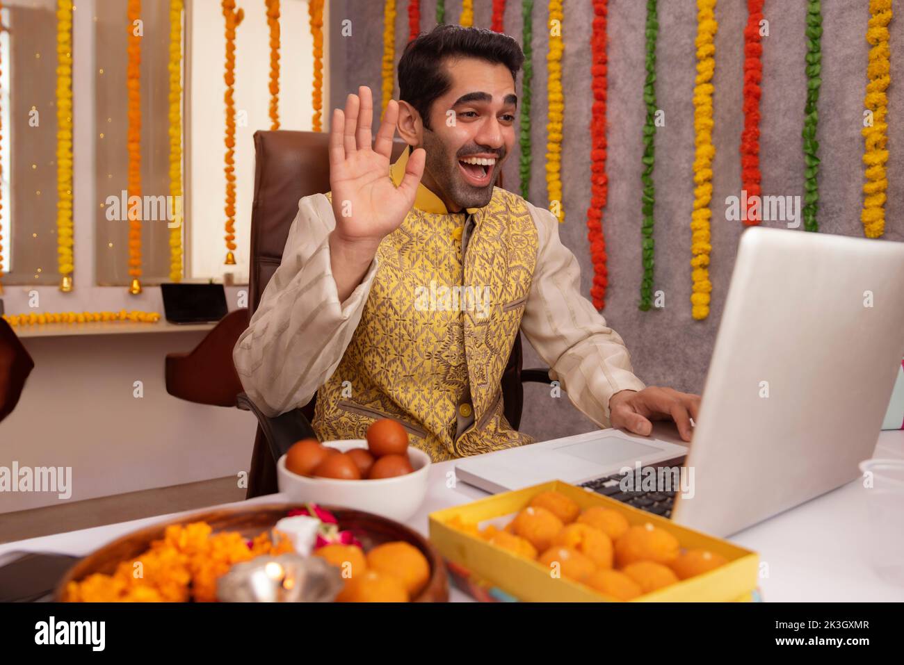 Mann, der während der Diwali-Feier einen Videoanruf auf dem Laptop im Büro hatte Stockfoto