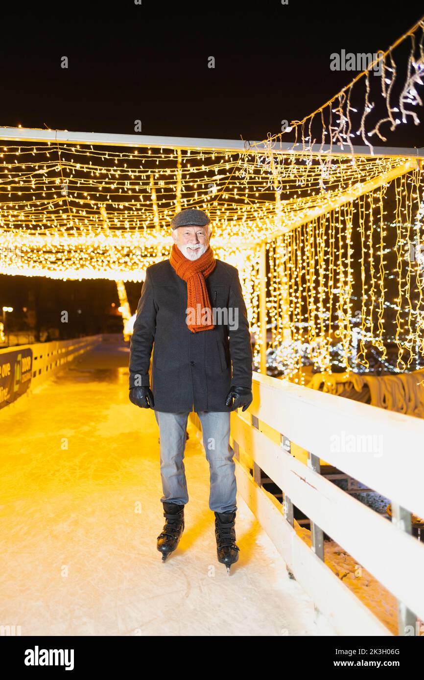 Älterer Mann mit Schlittschuhe Stockfoto