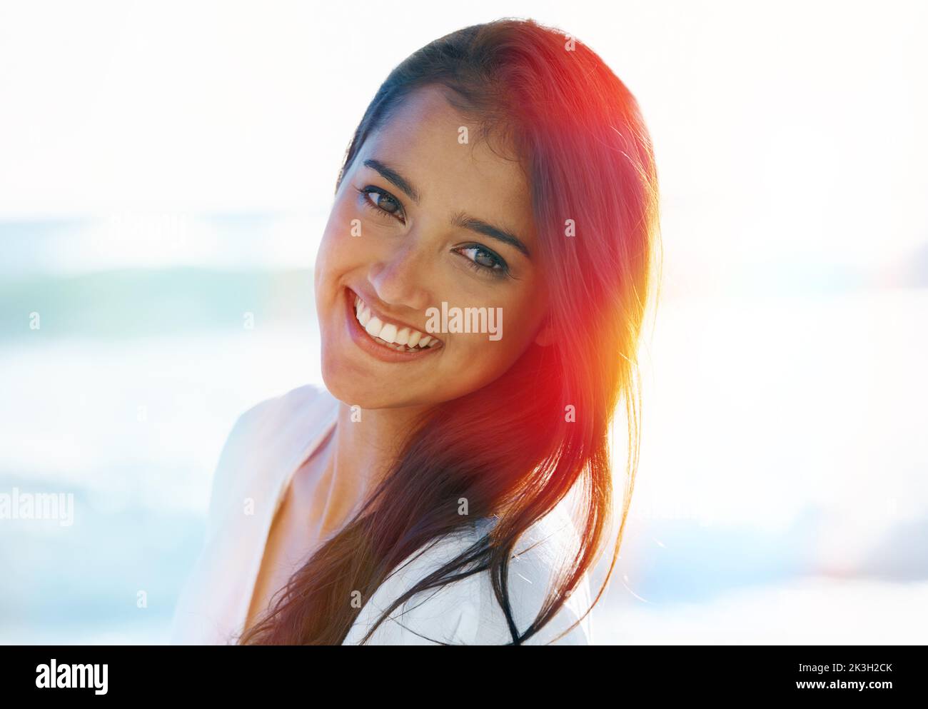 Süßes Sommerlächeln. Hübsche Frau, die draußen steht und die Kamera anlächelt. Stockfoto