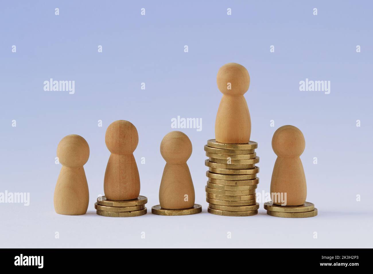 Schachfiguren auf Münzstapeln - Konzept der wirtschaftlichen Ungleichheit Stockfoto