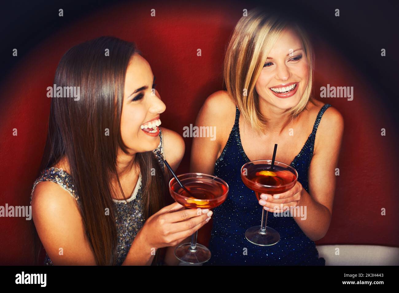Aufholen bei Getränken. Zwei junge Frauen genießen Cocktails in einem Nachtclub. Stockfoto