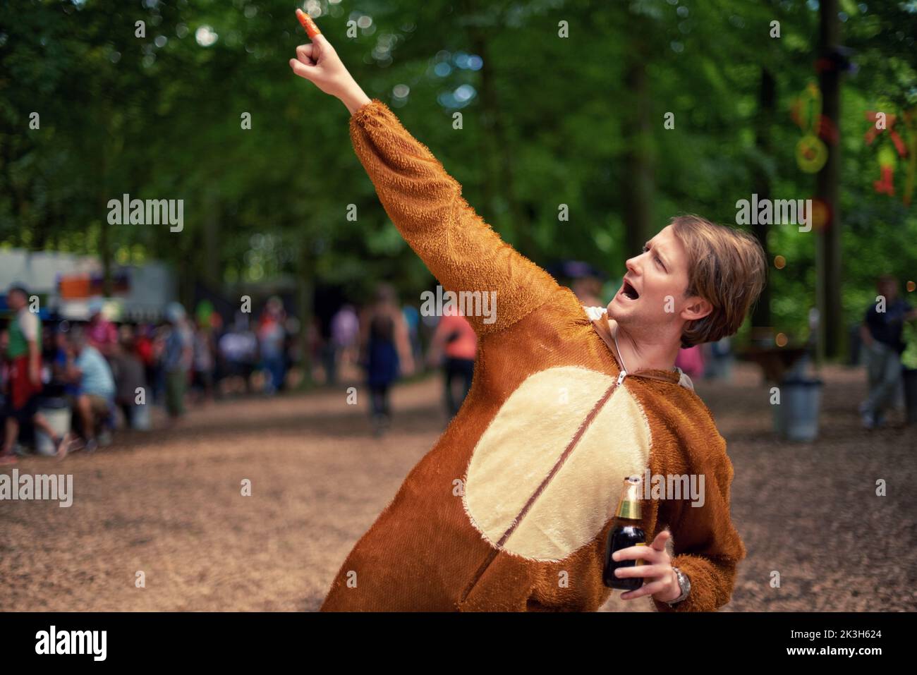 Partytier. Ein junger Mann, der draußen trinkt, während er in einem Tierkostüm gekleidet ist. Stockfoto
